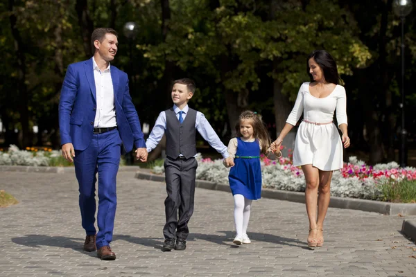 Glückliche Familie spaziert die Vorstadtstraße entlang — Stockfoto