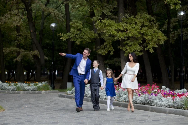 Felice famiglia a piedi lungo la strada suburbana — Foto Stock