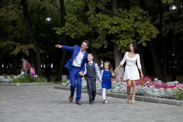 Familia feliz caminando a lo largo de la calle suburbana —  Fotos de Stock