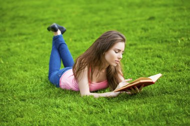 Genç güzel esmer kız açık bir kitap okuma