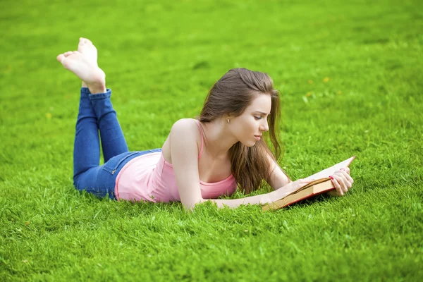 Junge schöne brünette Mädchen lesen ein Buch im Freien — Stockfoto
