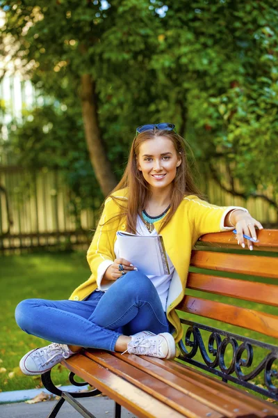 Schöne junge Frau im gelben Mantel — Stockfoto