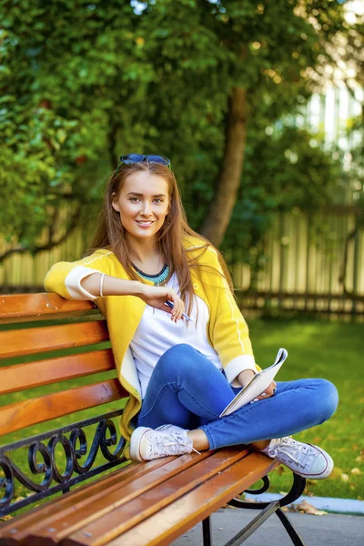 Mooie jonge vrouw in gele jas — Stockfoto