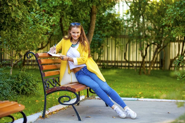 Beautiful young woman in yellow coat — Stock Photo, Image