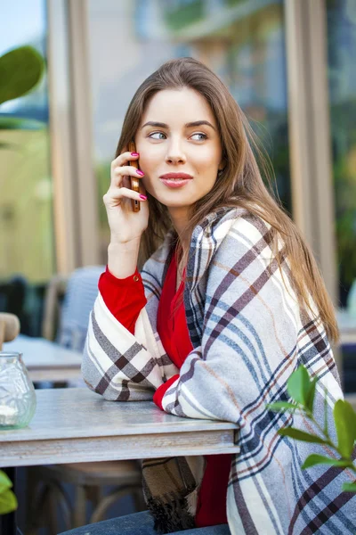 Όμορφη κοπέλα κάθεται στο καλοκαίρι café και καλώντας από τηλέφωνο — Φωτογραφία Αρχείου