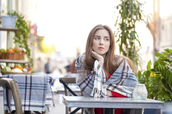 Retrato de uma bela jovem sentada em um café no stre — Fotografia de Stock