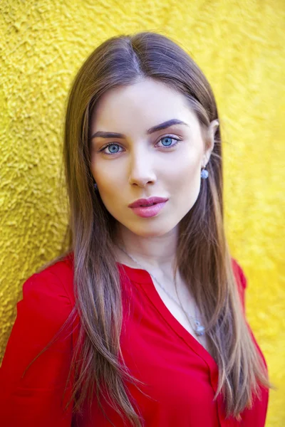 Mujer joven atractiva, contra el fondo de la pared amarilla — Foto de Stock