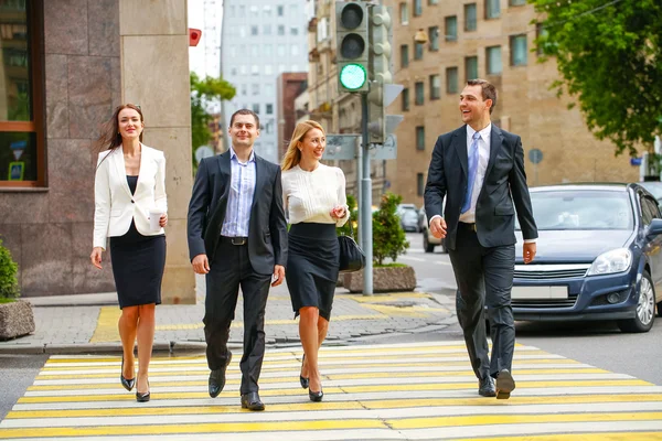 Four successful business people crossing the street in the city — Stock Photo, Image