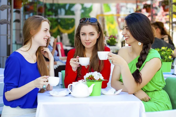 Tres amigas felices mujer sentada en una mesa en el verano c — Foto de Stock