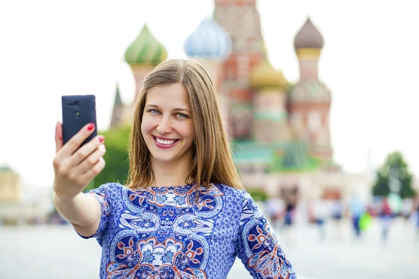 Gelukkig mooi meisje gefotografeerd op een mobiele telefoon — Stockfoto