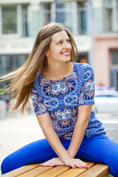 Happy Beautiful young woman sits on a bench — Stock Photo, Image