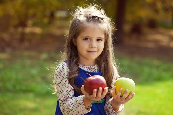 Portrait of a little girl with two large apples — Stock Photo, Image