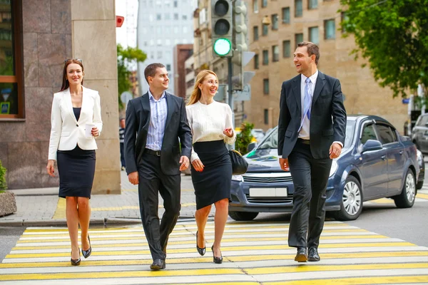 Vier succesvolle zakenmensen oversteken van de straat in de stad — Stockfoto