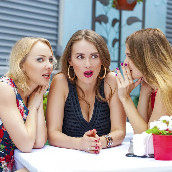 Τρεις όμορφες φίλες που κουτσομπολεύουν γυναίκα που κάθεται σε ένα τραπέζι μου — Φωτογραφία Αρχείου