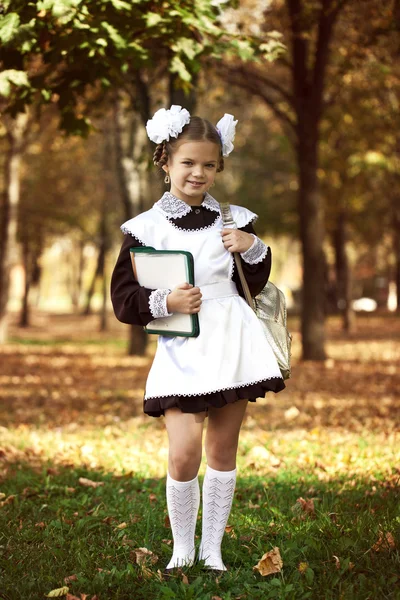 Porträtt av en vacker ung första-grader i en festlig skolan u — Stockfoto