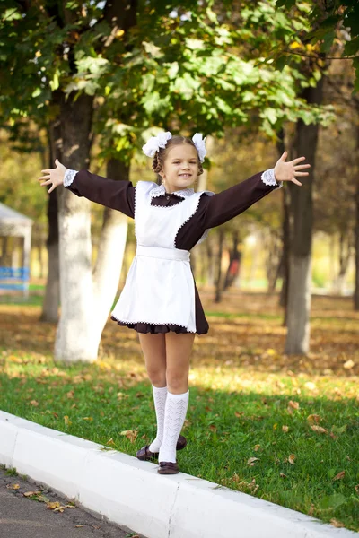 Retrato de una hermosa joven de primer grado en una escuela festiva u — Foto de Stock