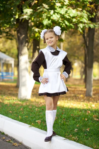 Retrato de una hermosa joven de primer grado en una escuela festiva u — Foto de Stock