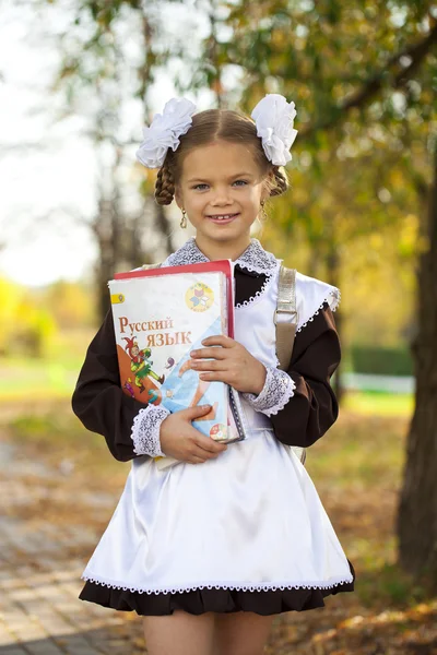 Šťastná malá školačka v podzimním parku — Stock fotografie