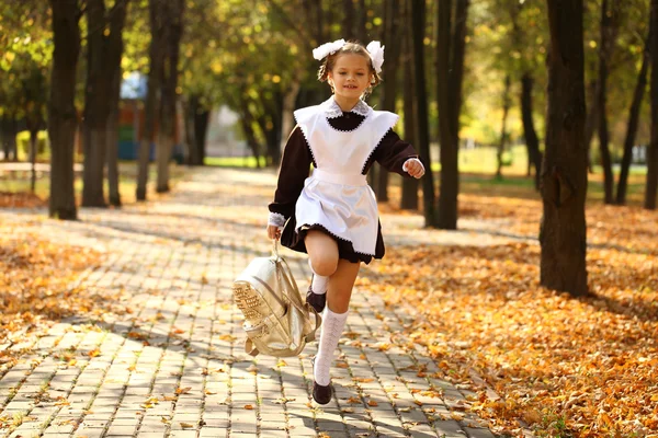 幸せな小さな女子高生が学校から家に帰る — ストック写真