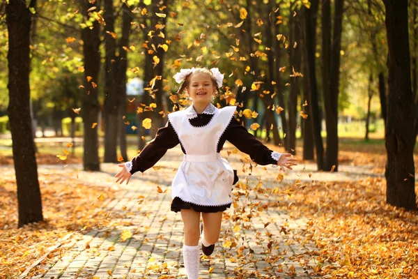 幸せな小さな女子高生が学校から家に帰る — ストック写真