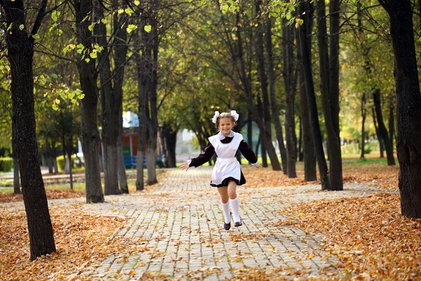 Счастливая маленькая школьница идет домой из школы — стоковое фото