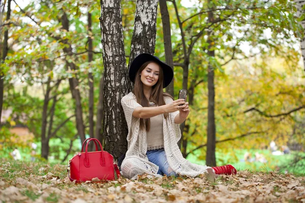 Joven hermosa mujer fotografiándose a sí mismos en un teléfono celular w — Foto de Stock