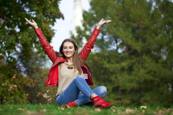 Kırmızı deri ceket ve kot sittin hppy güzel kadın — Stok fotoğraf