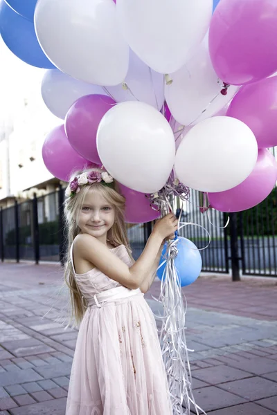 Piccola ragazza di cinque anni in un abito rosa con in mano palloncini — Foto Stock