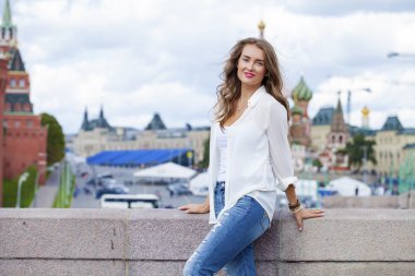 Genç güzel kadın beyaz bluz ve kot yürüyüş