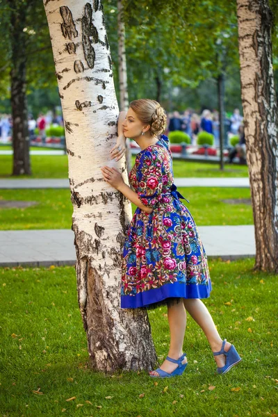 Schöne blonde Frau auf einem Baum im Wald — Stockfoto