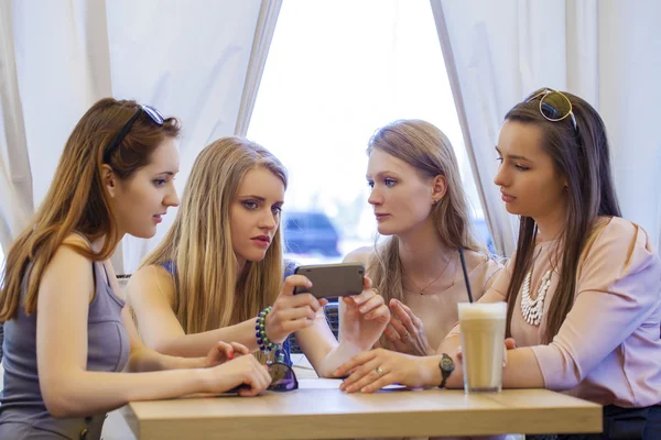 Grupo de mujeres jóvenes sentadas alrededor de la mesa comiendo postre — Foto de Stock