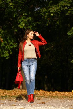 Genç kadın moda kırmızı ceket ve kırmızı çanta sonbahar yürüyüş içinde