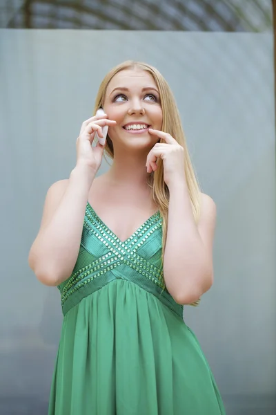 Ung vacker flicka i den gröna klänningen talar i mobiltelefon — Stockfoto