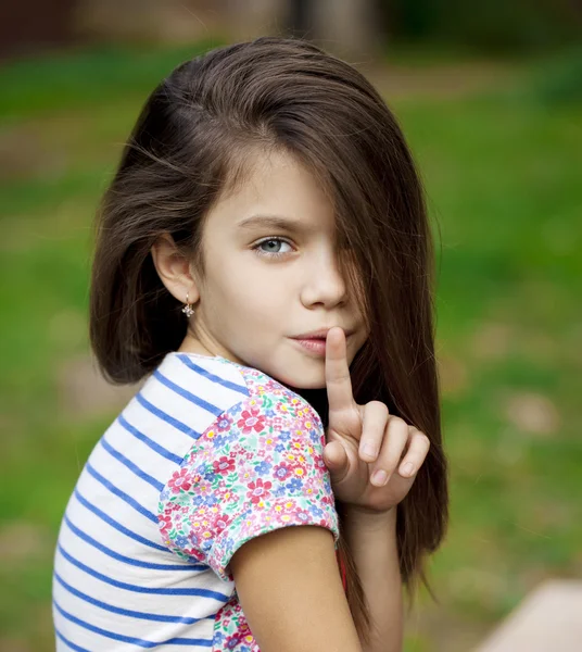 Little girl has put forefinger to lips as sign of silence — Stock Photo, Image