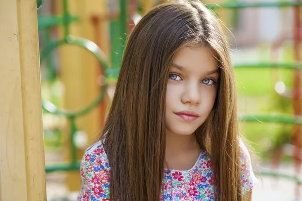 Hermosa niña en el fondo verde del parque de la ciudad de verano — Foto de Stock