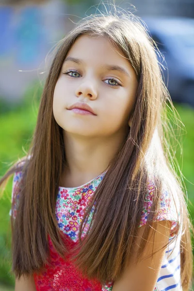 Hermosa niña en el fondo verde del parque de la ciudad de verano —  Fotos de Stock