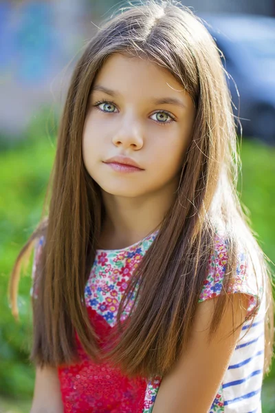 Vacker liten flicka på grön bakgrund sommaren stadspark — Stockfoto
