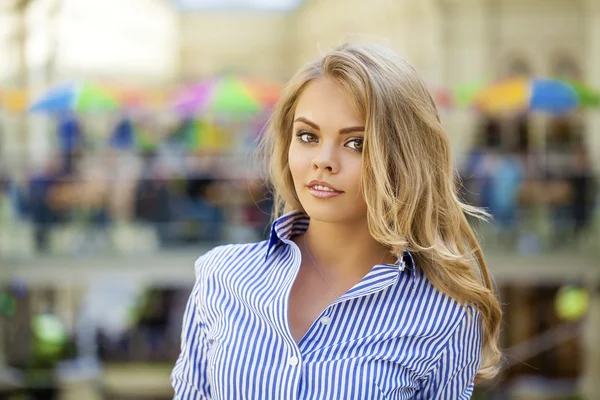 Portret van een mooie blonde in een blauwe gestreepte shirt — Stockfoto