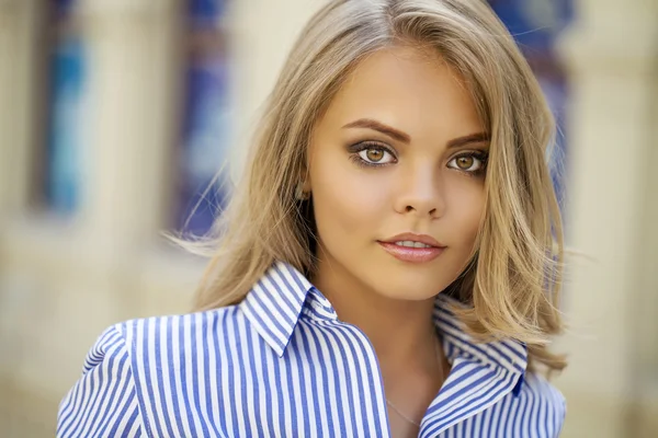 Portret van een mooie blonde in een blauwe gestreepte shirt — Stockfoto