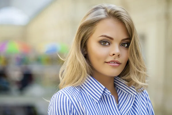 Portret van een mooie blonde in een blauwe gestreepte shirt — Stockfoto