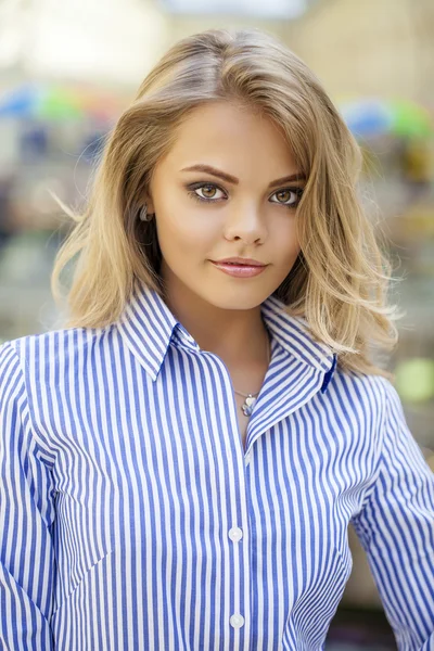 Retrato de una hermosa rubia con una camisa de rayas azules — Foto de Stock