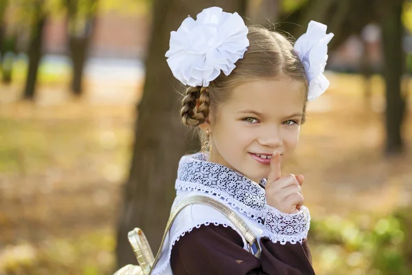 Porträtt av en vacker ung första-grader i en festlig skolan u — Stockfoto