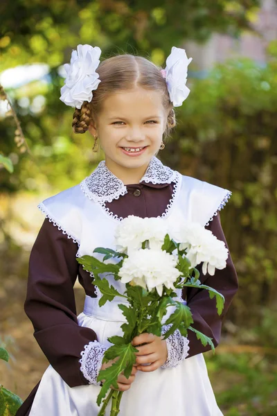 Porträt einer schönen jungen Erstklässlerin in einer festlichen Schule — Stockfoto