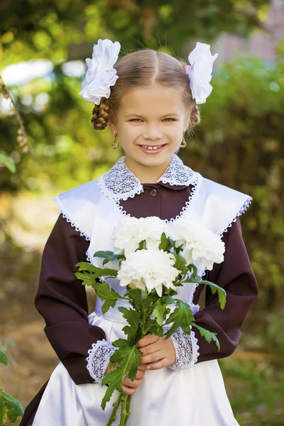 Portrait of a beautiful young first-grader in a festive school u — Stock Photo, Image
