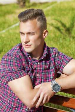 Yaz arka plan üzerinde ekose gömlekli sakin yakışıklı adam