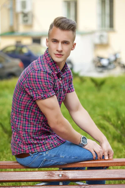 Ruhiger, gutaussehender Mann im karierten Hemd auf dem Hintergrund der Sommerstraße — Stockfoto