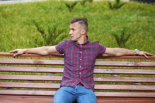 Ruhiger, gutaussehender Mann im karierten Hemd auf dem Hintergrund der Sommerstraße — Stockfoto