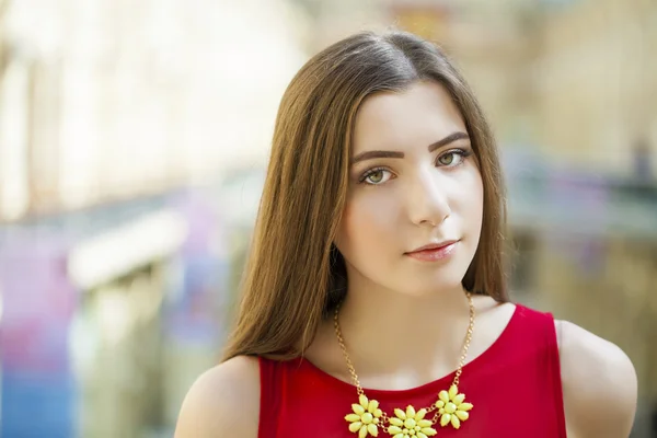 Young woman in red dress against the backdrop of a shopping cent — Stock Photo, Image