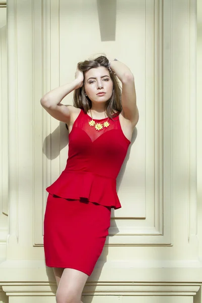 Szexi barna, egy vörös ruhás fülledt portréja — Stock Fotó