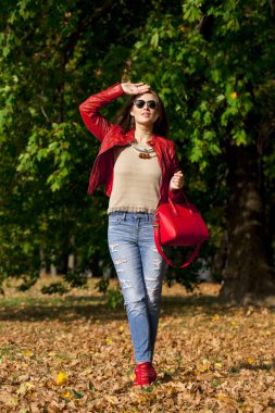 Genç kadın moda kırmızı ceket ve kot sonbahar Park